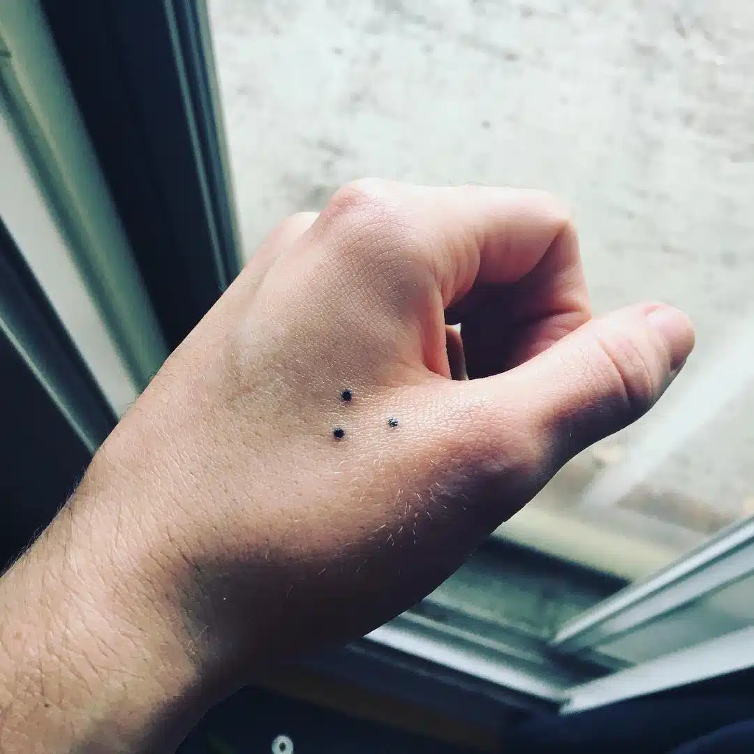 Tatouage minimaliste à trois points sur la main