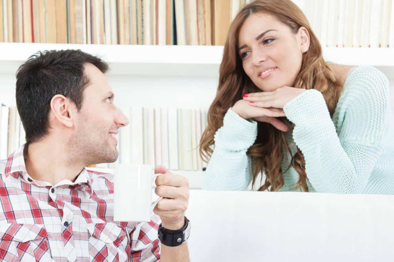 Femme souriante écoutant attentivement son partenaire lors d'une conversation