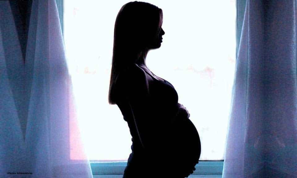 Femme souriante tenant un test de grossesse