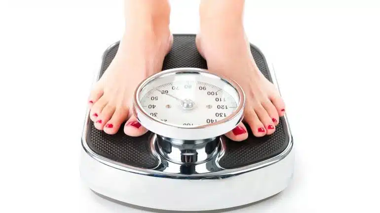 Femme souriante tenant une balance
