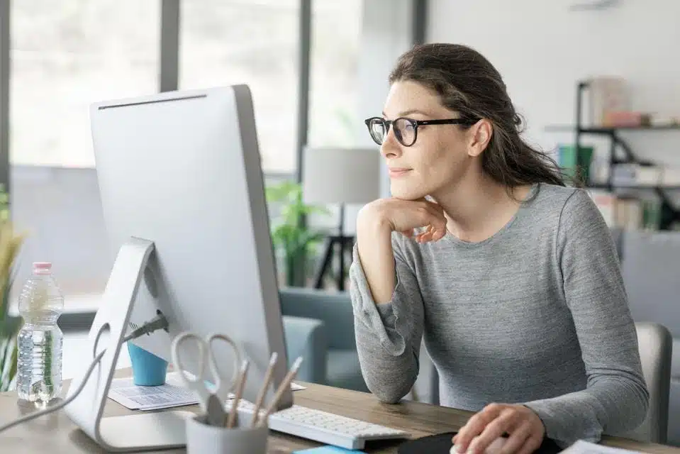 Femme travaillant sur son ordinateur portable avec des plans et des notes