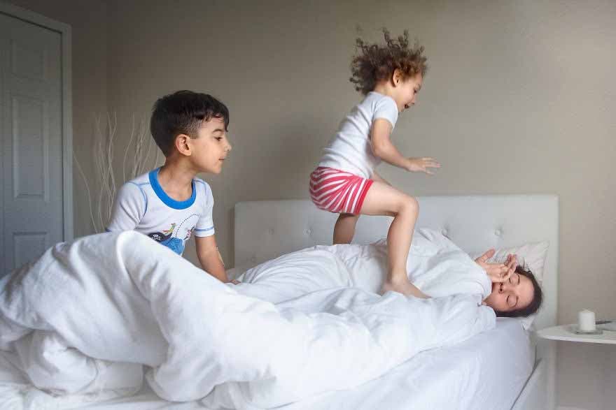 Des enfants jour avec leur mère qui dort