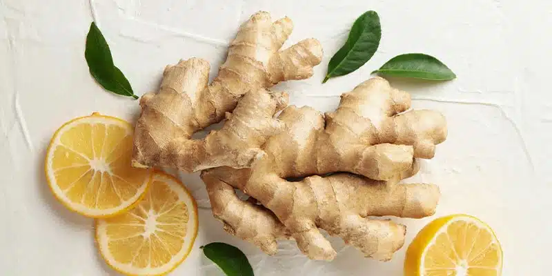 Gingembre frais et citrons coupés, illustrant les ingrédients du soin maison