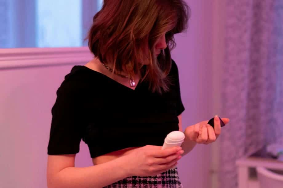 Femme appliquant du déodorant en spray sous son aisselle