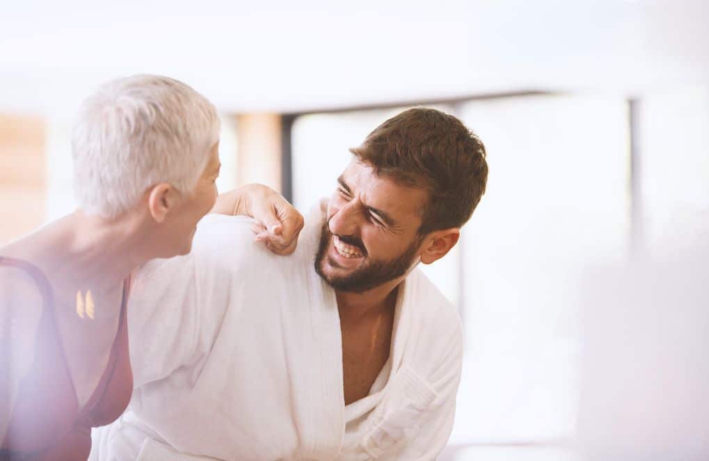 Femme souriante et épanouie en compagnie d'un homme plus jeune, dans un moment de complicité
