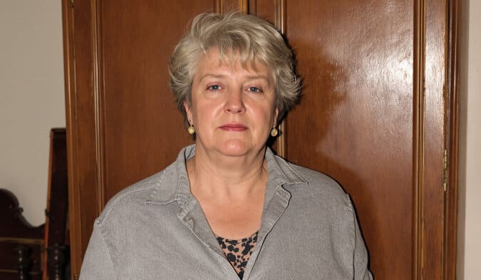 Vieilles photographies en noir et blanc éparpillées sur une table en bois, évoquant la recherche généalogique