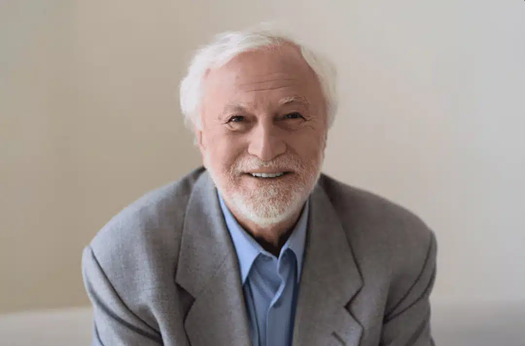 Personne âgée tenant un verre d'eau, illustrant l'importance de l'hydratation