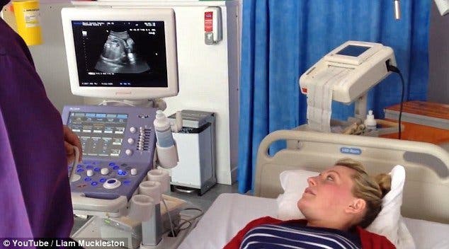 Un médecin appuie sur le ventre d’une femme enceinte