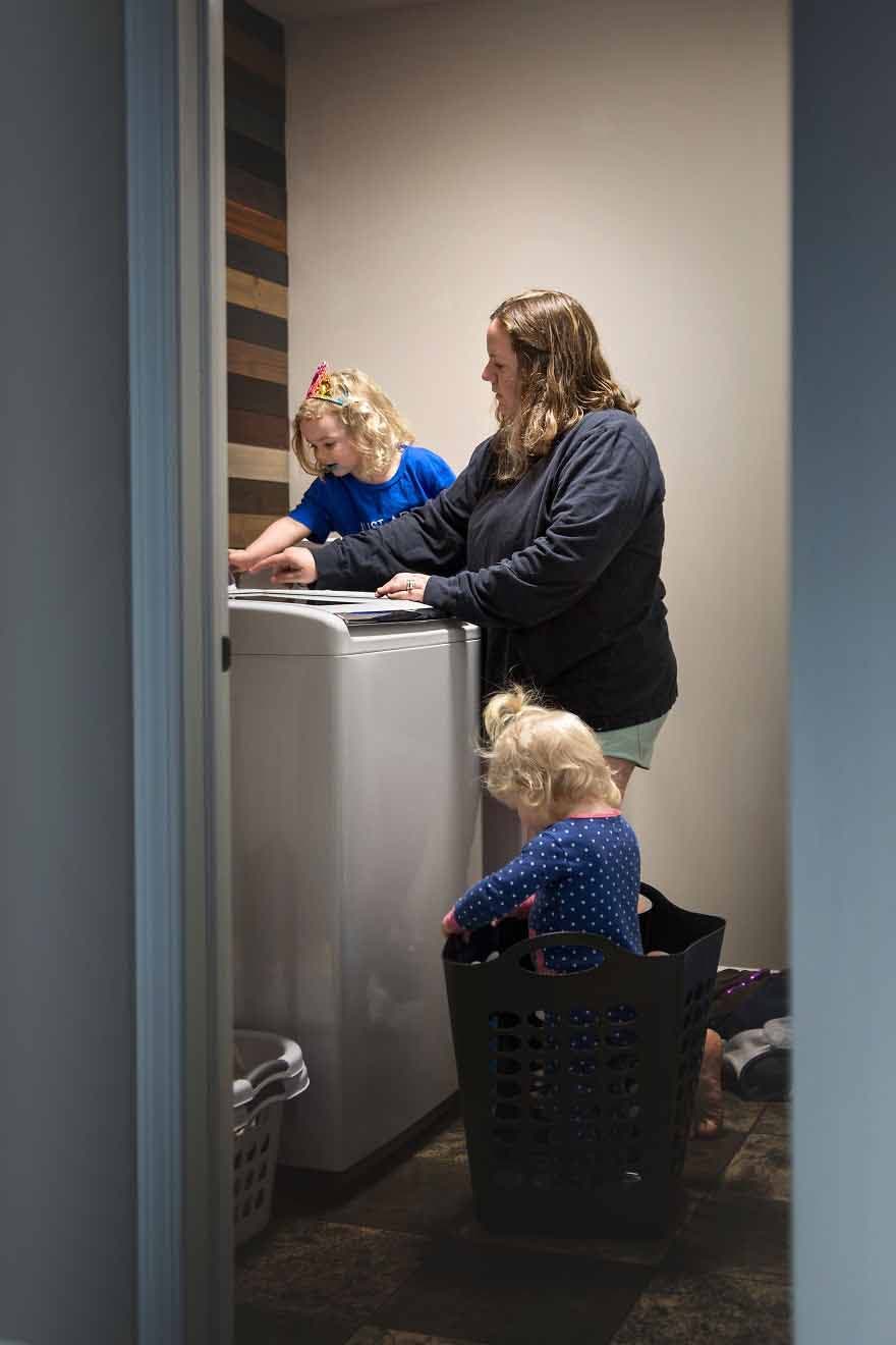Une maman qui fait la lessive et joue avec ses enfants