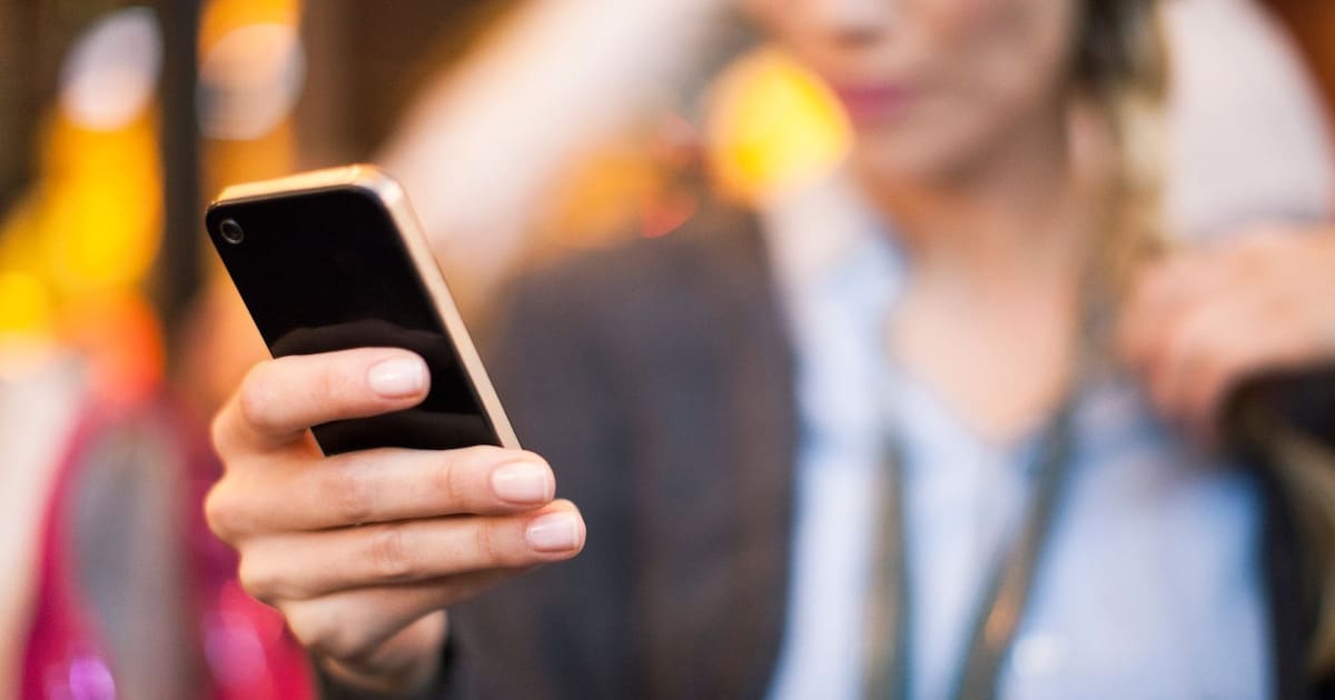 Un téléphone portable posé sur une table, écran allumé, symbolisant une conversation cruciale.