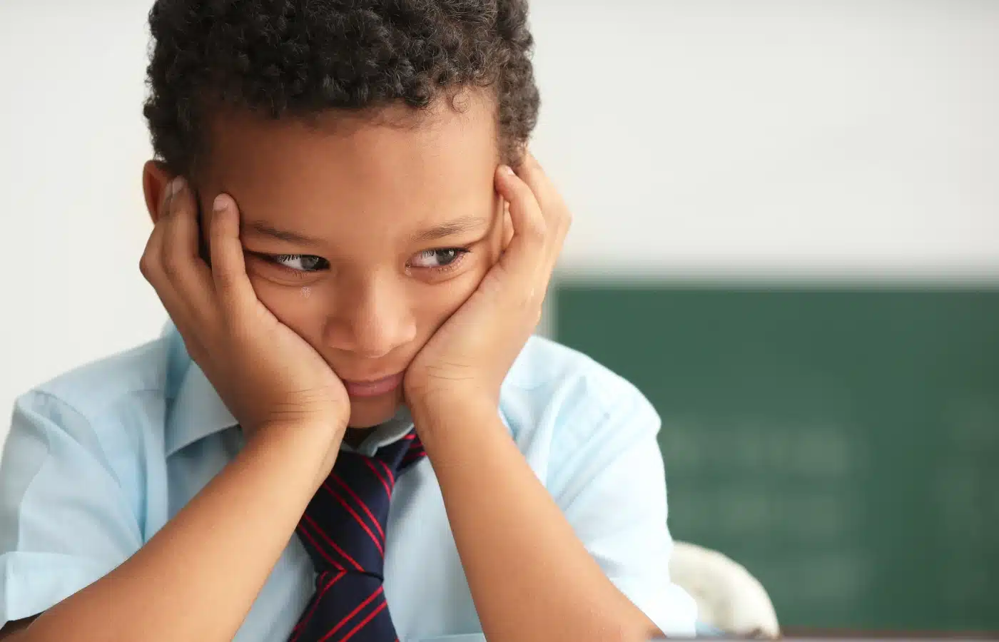 Enfant découragé devant son bureau