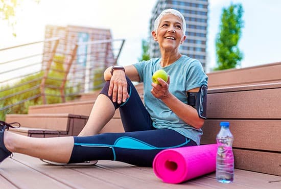 Femme senior souriante lors d'une séance de sport en extérieur