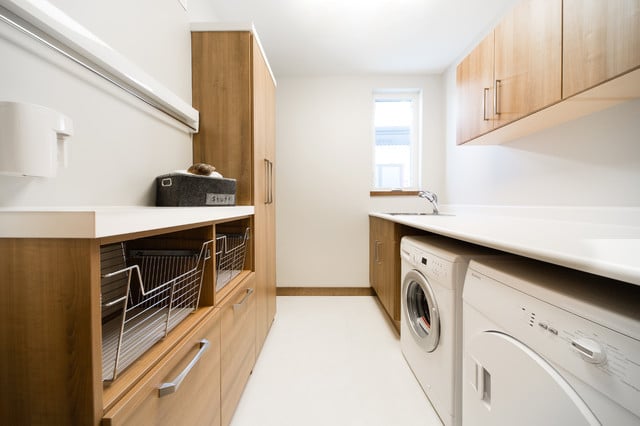 Buanderie d'une maison avec une femme pliant du linge