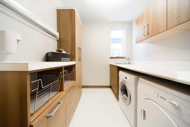 Buanderie d'une maison avec une femme pliant du linge