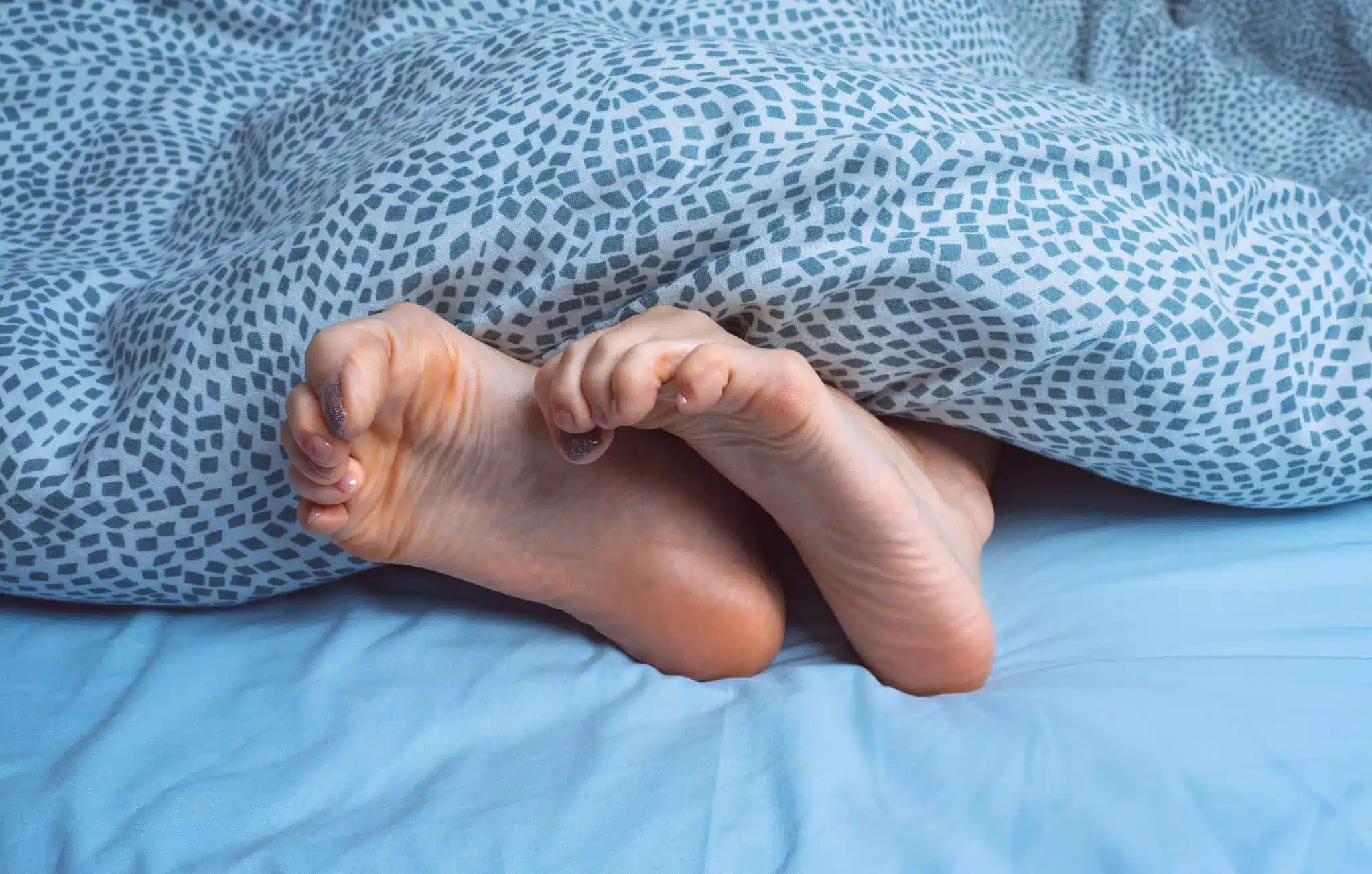 Femme se massant la jambe la nuit