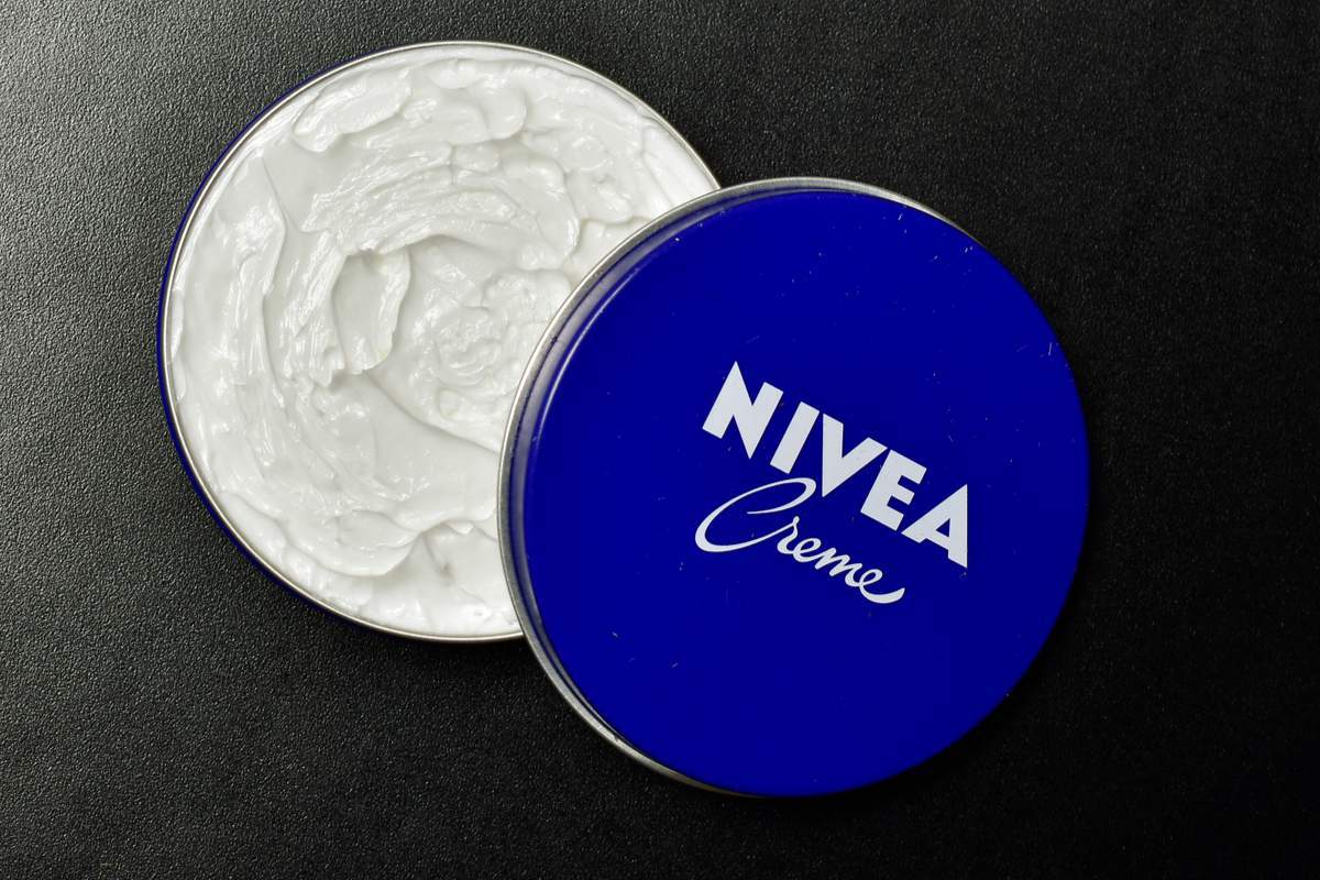 Pot bleu de crème Nivea posé sur une table en bois