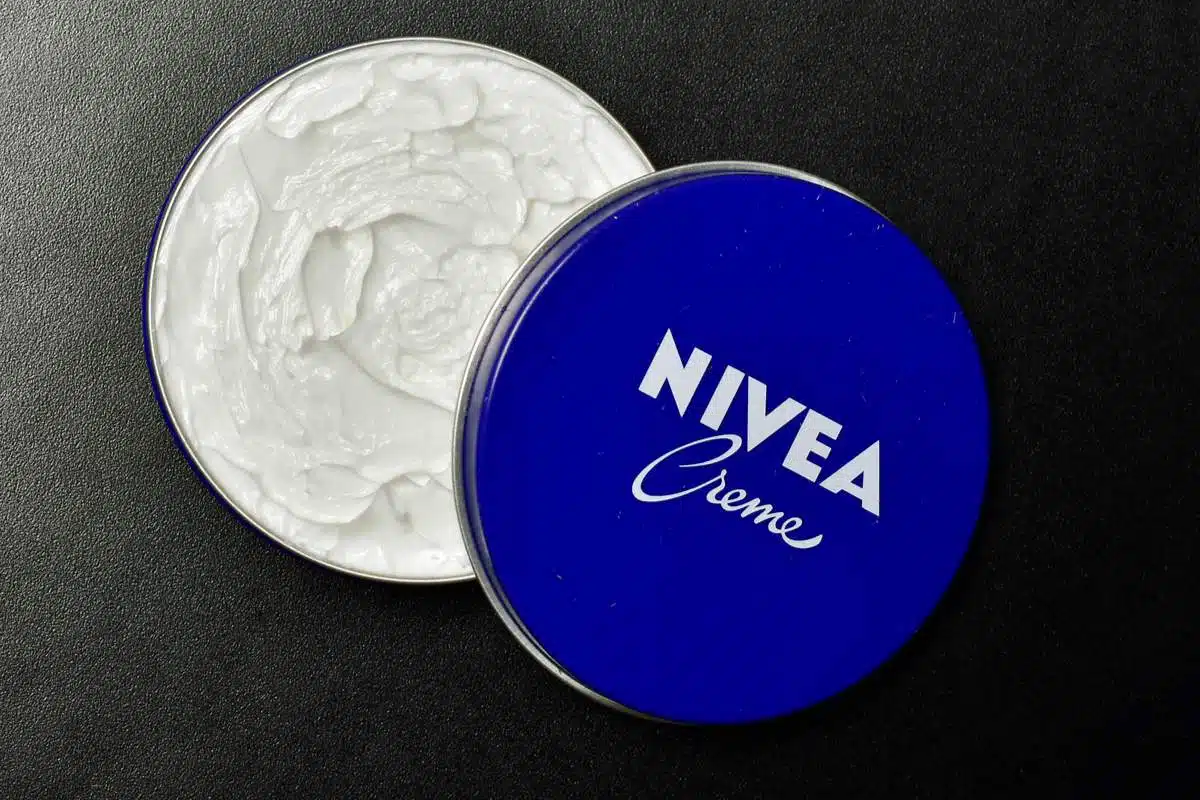 Pot bleu de crème Nivea posé sur une table en bois