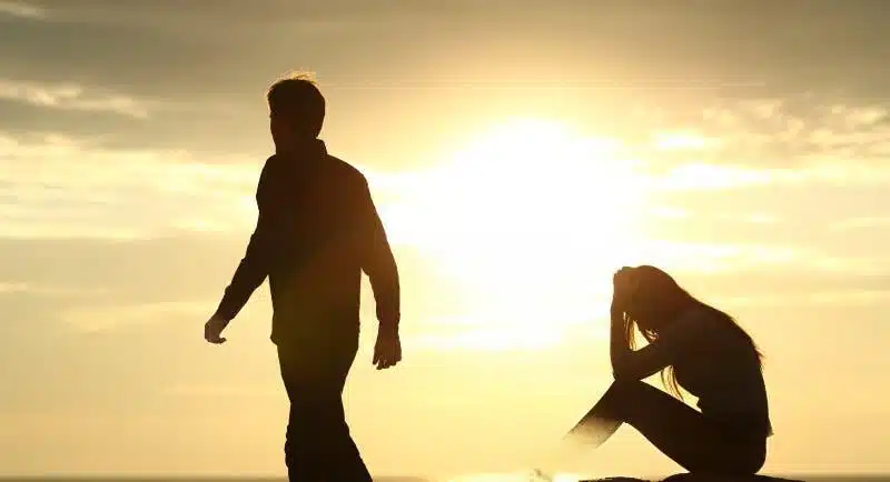 Couple en silhouette se séparant au coucher du soleil