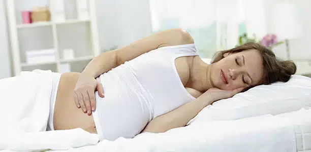 Femme enceinte dormant sur le côté gauche