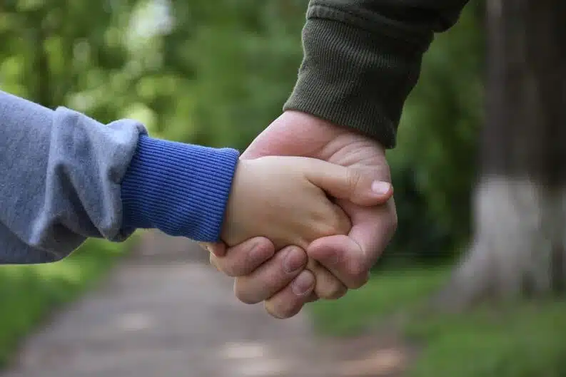 Main d'adulte tenant celle d'un enfant