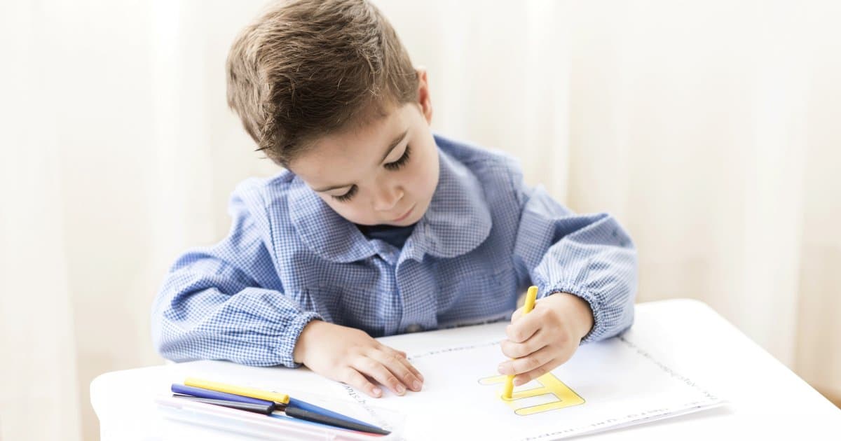 Jeune enfant gaucher en train de dessiner avec concentration