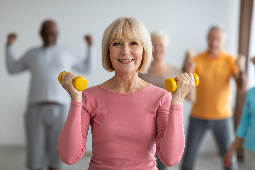 Femme senior pratiquant des exercices de gymnastique douce à domicile