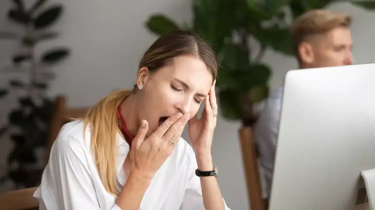 Femme fatiguée appuyée sur une table