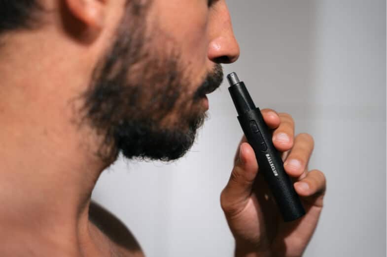 Personne utilisant des ciseaux spéciaux pour poils nasaux