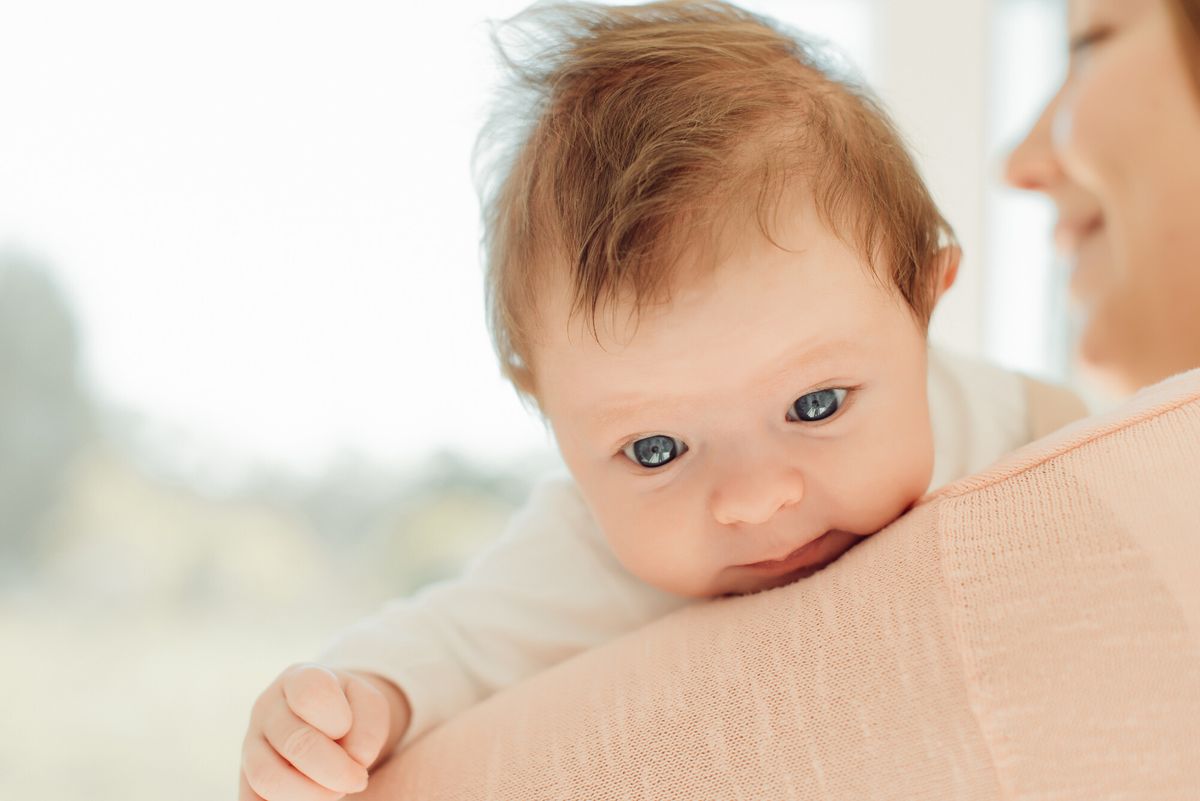 Jeune femme souriante portant un bébé dans un porte-bébé