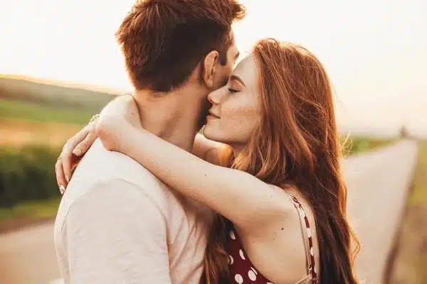Jeune couple enlacé au bord d'une route