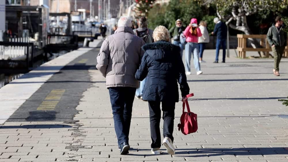 Couple âgé se tenant la main sur le port