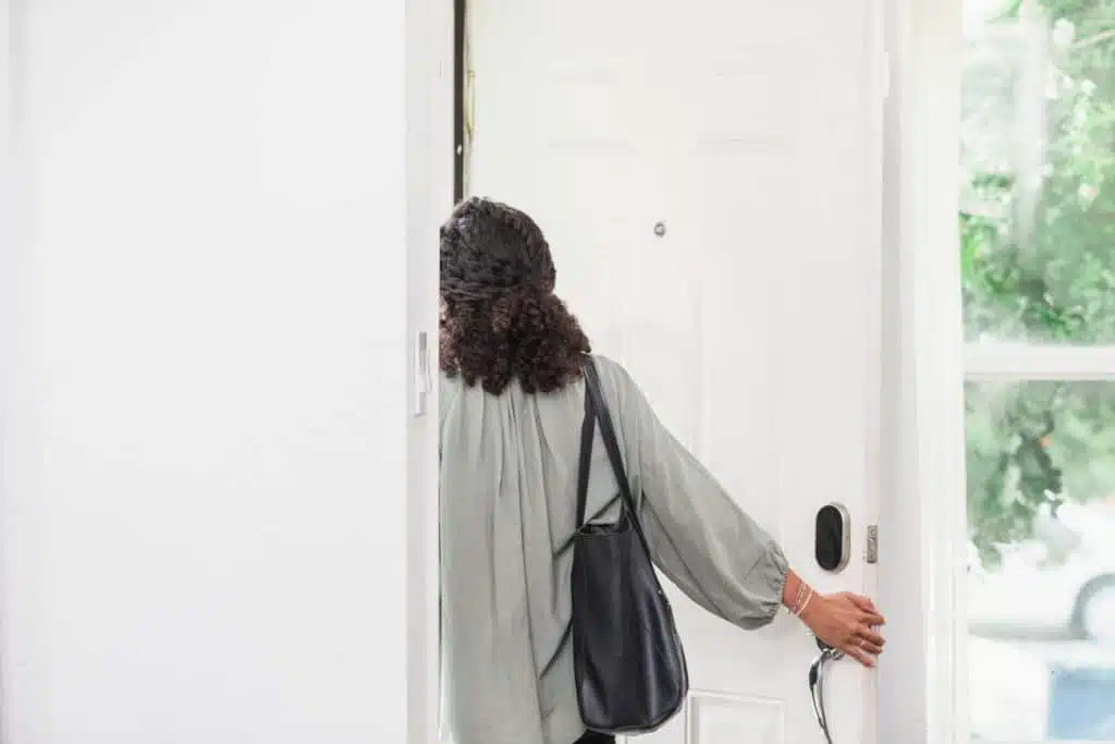 Jeune femme quittant une maison, perdue dans ses pensées