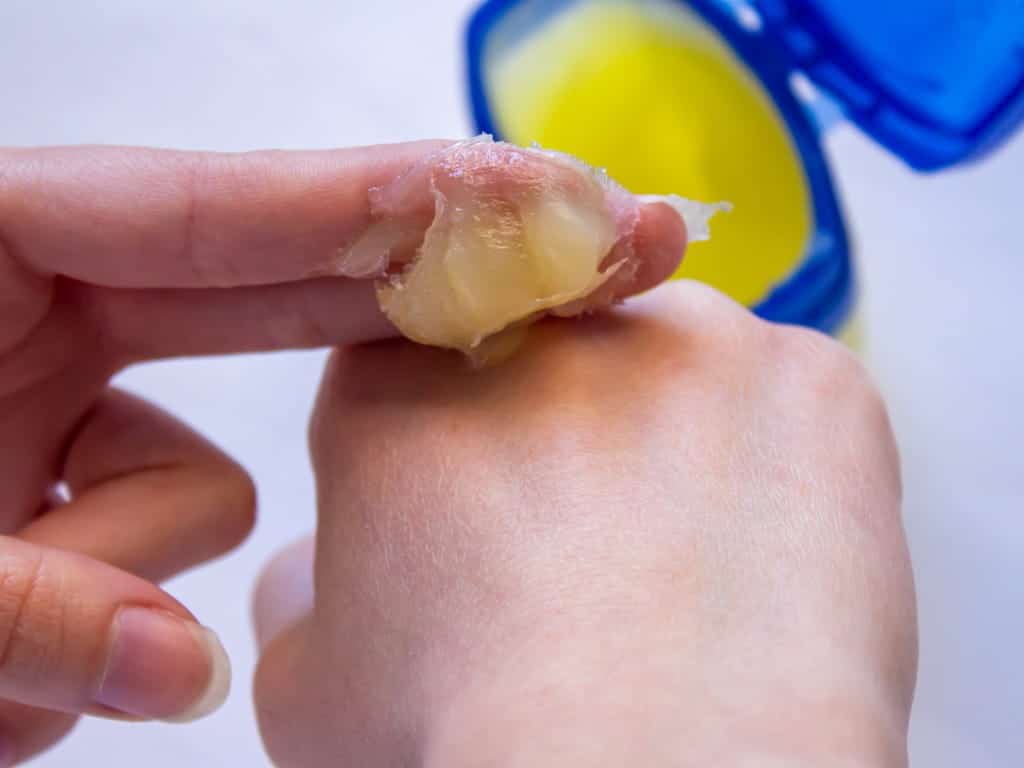 Femme appliquant de la vaseline sur sa main