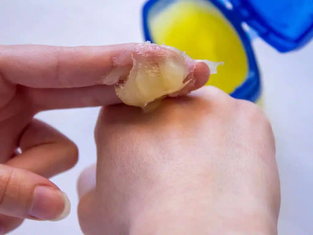 Femme appliquant de la vaseline sur sa main